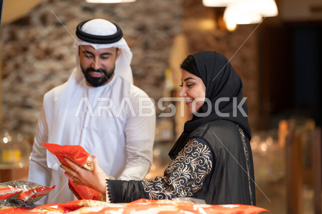 تسوق زوجين إماراتيين بالزي التقليدي في المتجر