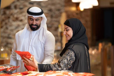 تسوق زوجين إماراتيين بالزي التقليدي في المتجر