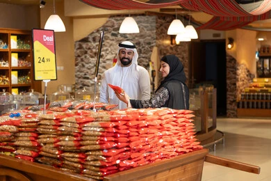 زوج إماراتي يتسوق المكسرات في سوق تقليدي