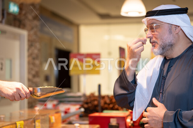 Emirati Man in Traditional Attire Sampling Food at Market