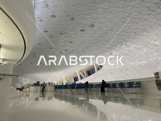 Innovative interior design for the King Abdulaziz Center for World Culture (Ithra) in Dhahran, unique geometric ceiling, spacious waiting and seating area, organized cultural environment, architectural geometric art, tourism in Saudi Arabia.