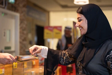 امرأة سعودية تتسوق البهارات بالعباءة التقليدية