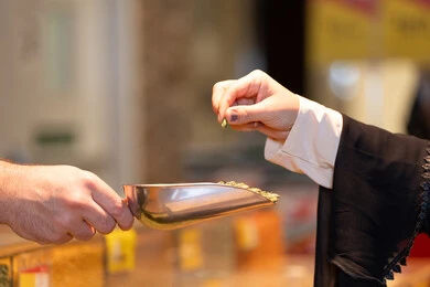 امرأة إماراتية تشتري الهيل الأخضر من سوق التوابل