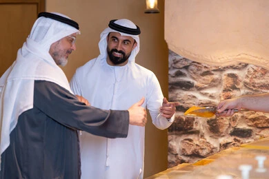 رجال إماراتيون بالزي التقليدي في سوق التوابل