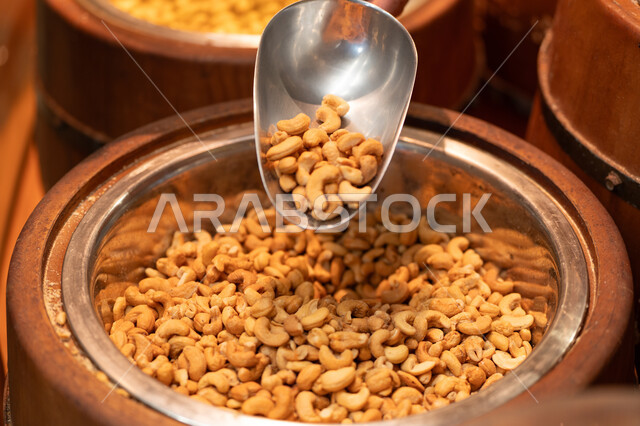حبات كاجو محمص مع ملعقة معدنية في السوق