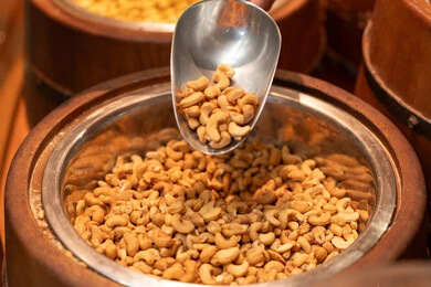 حبات كاجو محمص مع ملعقة معدنية في السوق