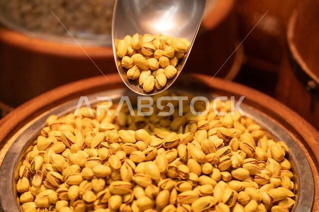 Roasted pistachios in a wooden barrel at the spice market.
