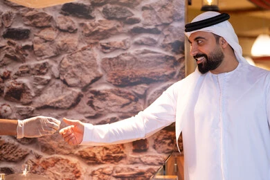 Emirati Man in Traditional Kandura Receiving Coffee Emirati Man in Traditional Kandura Receiving Coffee