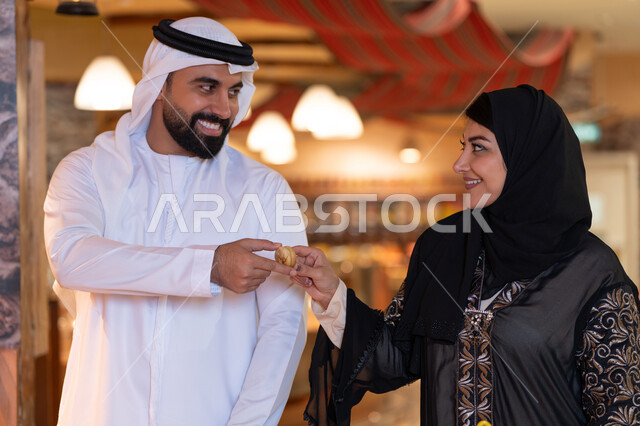 Emirati Couple in Traditional Attire Sharing Food