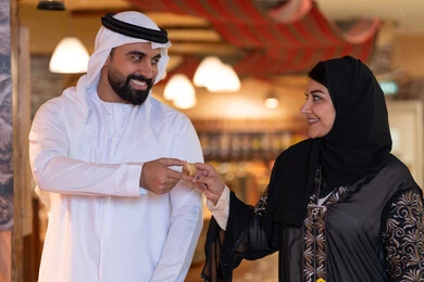 زوجان إماراتيان بالزي التقليدي يشاركان الطعام
