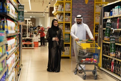زوجين إماراتيين يتسوقان في ممر سوبر ماركت حديث
