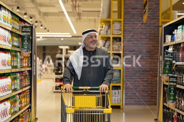رجل إماراتي يتسوق بعربة في السوبر ماركت