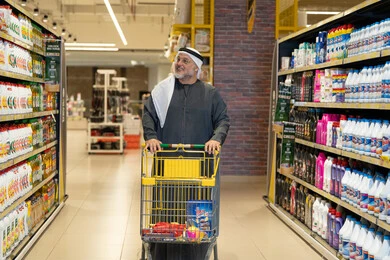 Emirati Man Shopping with Trolley in Supermarket