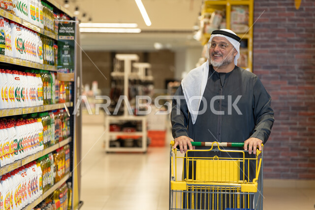 رجل خليجي يتسوق بعربة تسوق في السوبر ماركت