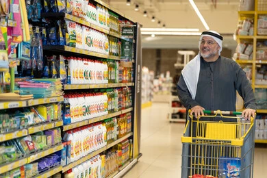 رجل إماراتي يتسوق في السوبر ماركت مع عربة