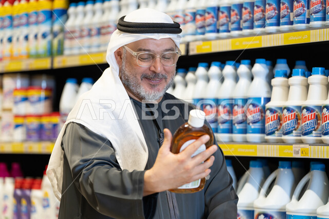 رجل عربي يتسوق لشراء منظفات منزلية في السوبر ماركت