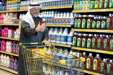 رجل عربي مسن يتسوق منتجات التنظيف في السوبر ماركت