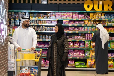 Emirati Couple Shopping in Supermarket Pet Food Aisle