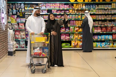 زوجان إماراتيان يلتقطان سيلفي في ممر السوبر ماركت