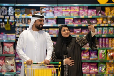 زوجان إماراتيان يلتقطان سيلفي في ممر السوبر ماركت