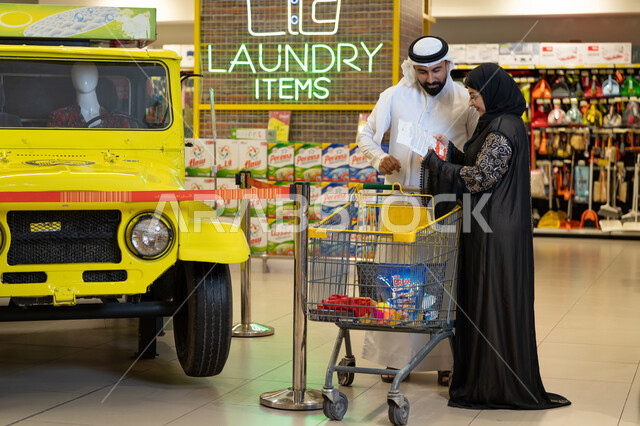 زوجان إماراتيان يتسوقان في قسم المنظفات بالسوبر ماركت