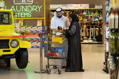 زوجان إماراتيان يتسوقان في ممر المنظفات بالمتجر