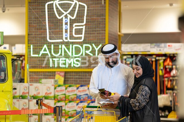 زوجان إماراتيان يتسوقان في قسم المنظفات بالسوبر ماركت