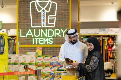 زوجان إماراتيان يتسوقان في قسم المنظفات بالسوبر ماركت