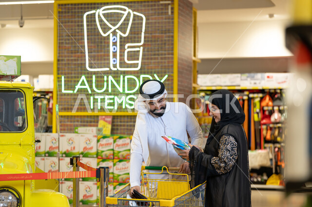 Arab Couple Shopping for Laundry Items in Supermarket