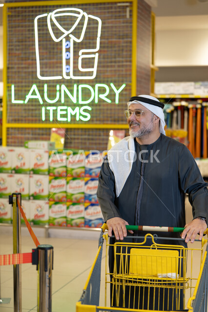 رجل إماراتي يتسوق في قسم المنظفات بالمتجر