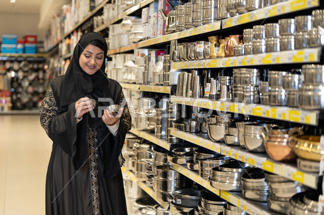 امرأة سعودية تتسوق لشراء أدوات المطبخ في متجر