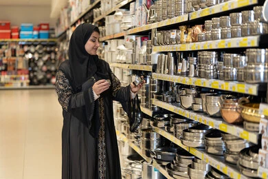 امرأة عربية تتسوق أدوات منزلية في السوبر ماركت