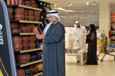رجل إماراتي يتسوق أواني فخارية في متجر حديث