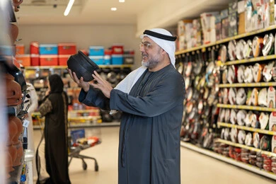 رجل إماراتي يتسوق لشراء أدوات المطبخ في السوبر ماركت