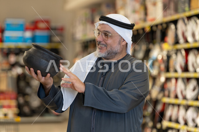 Arab Man Shopping for Traditional Pot in Supermarket