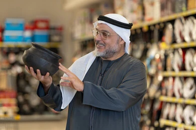 Arab Man Shopping for Traditional Pot in Supermarket