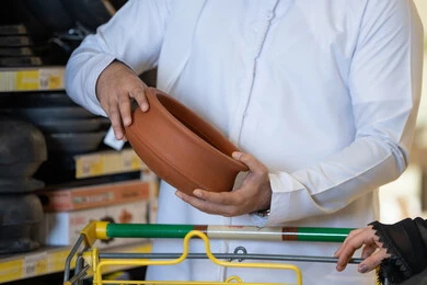 Saudi Man Inspecting Clay Pottery in Retail Store