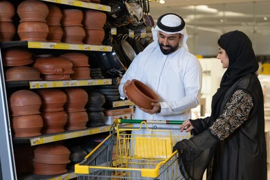 رجل وامرأة إماراتيان يتسوقان أواني فخارية في متجر