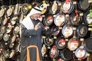 رجل إماراتي يتسوق لشراء أواني الطهي في قسم المطبخ