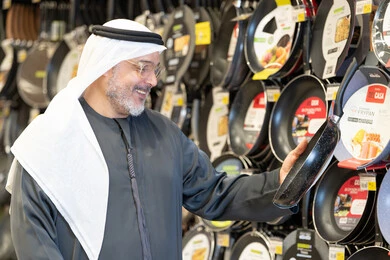 رجل إماراتي يتسوق لشراء أواني منزلية في المتجر