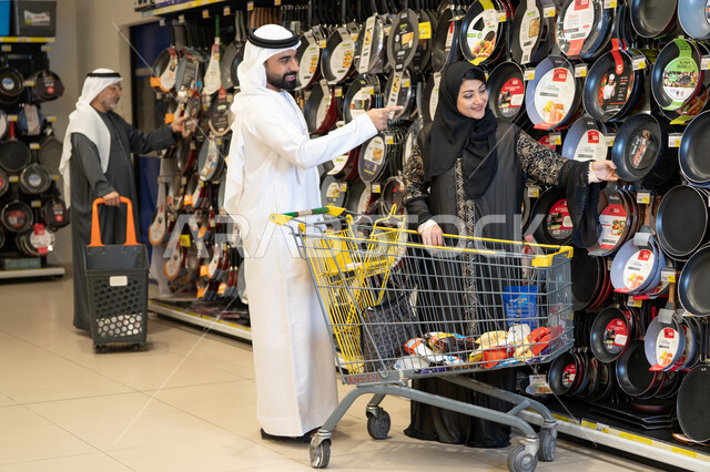 زوجان إماراتيان يتسوقان أدوات المطبخ في السوبر ماركت