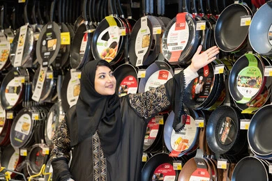 امرأة سعودية تتسوق أواني المطبخ في متجر تجزئة