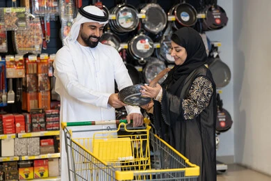 زوجين إماراتيين يتسوقان أدوات المطبخ في سوبر ماركت