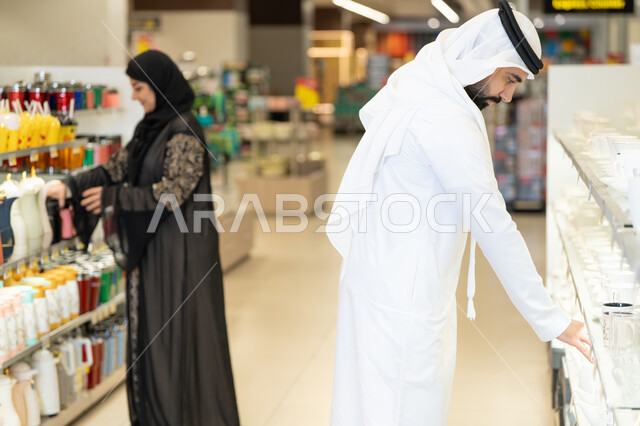 زوجين سعوديين يتسوقان أدوات منزلية في السوبر ماركت