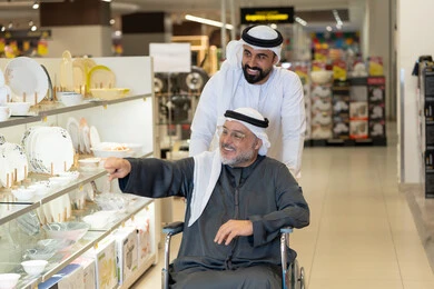 Emirati Man in Wheelchair Shopping at Mall Store