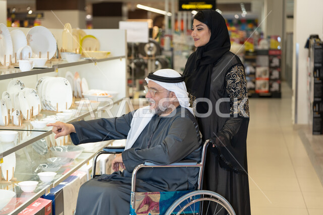رجل عربي مسن يتسوق على كرسي متحرك