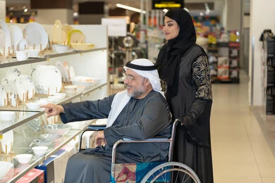 رجل عربي مسن يتسوق على كرسي متحرك رجل عربي مسن يتسوق على كرسي متحرك