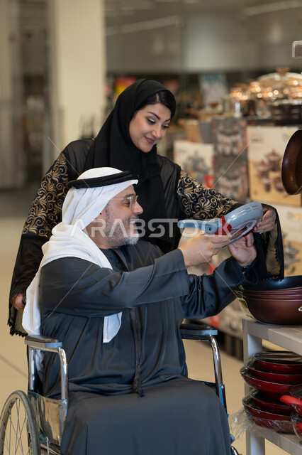 رجل إماراتي على كرسي متحرك يتسوق أواني منزلية