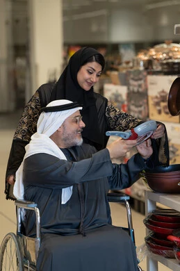 رجل إماراتي على كرسي متحرك يتسوق أواني منزلية