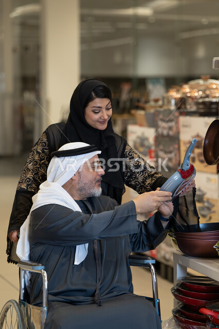 رجل إماراتي على كرسي متحرك يتسوق أدوات المطبخ